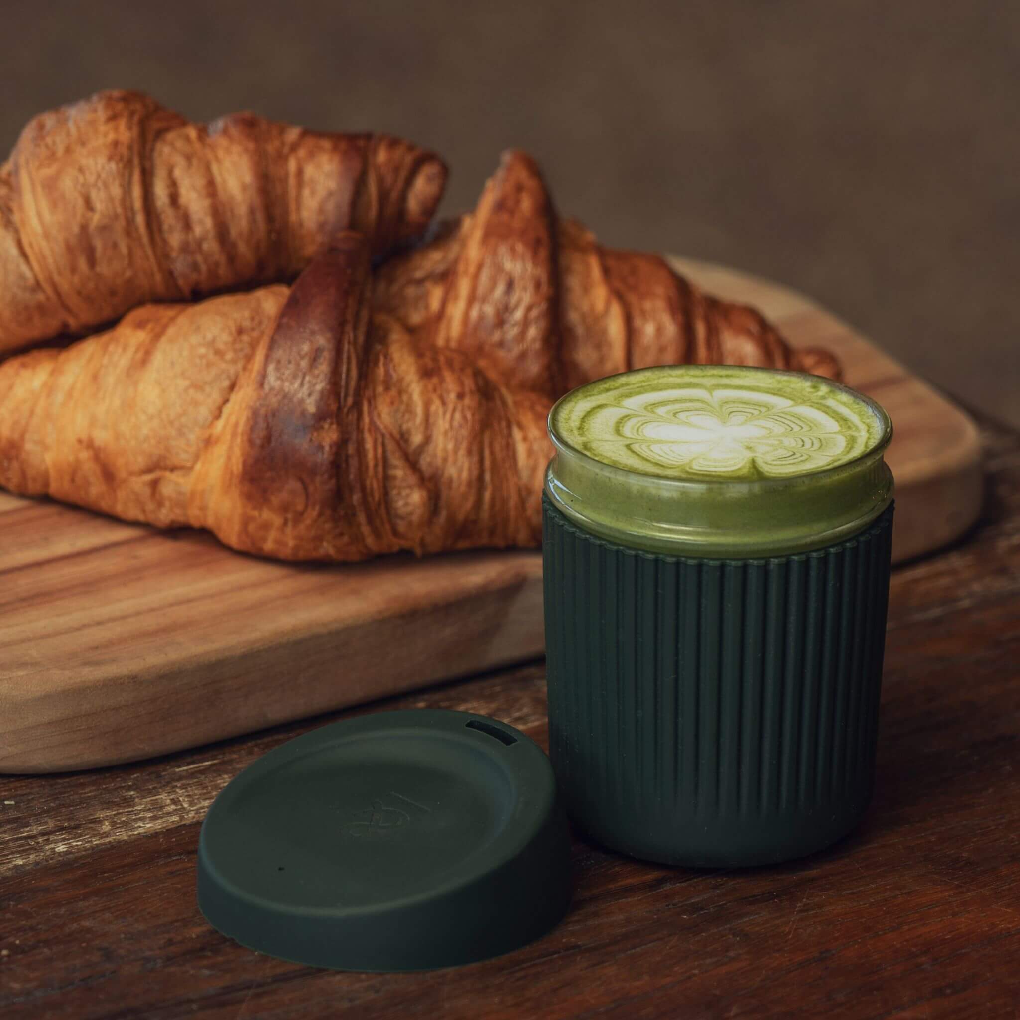 breakfast green tea in a glass cup with croissants