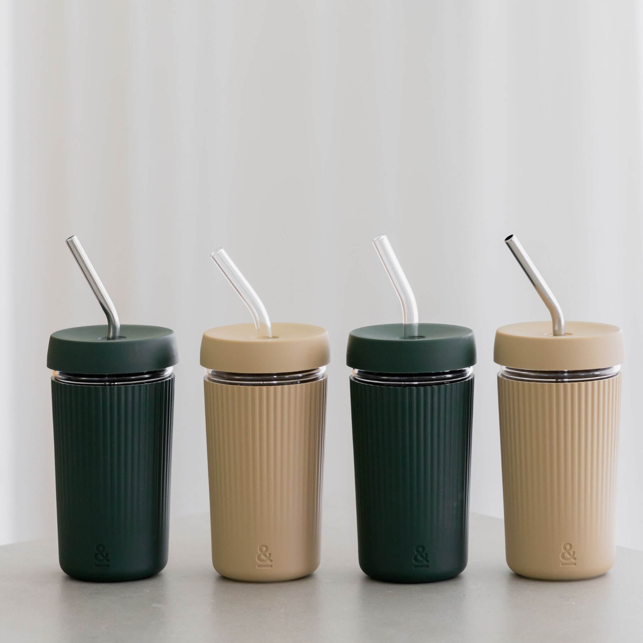 a row of soda and beer glasses with glass and metal straws