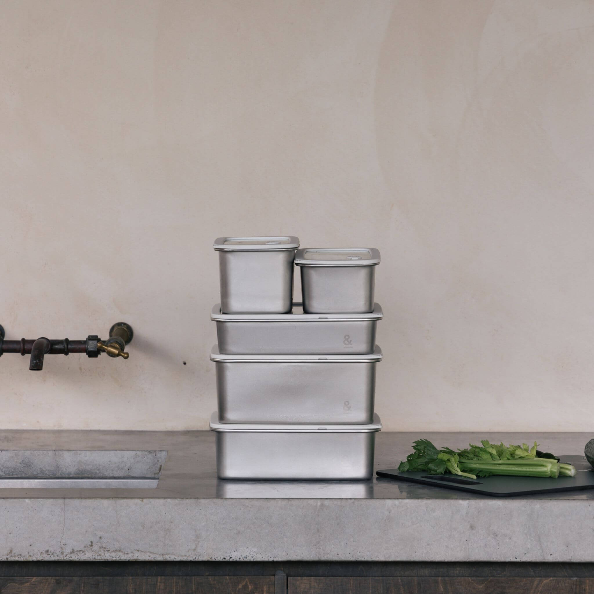 All five Rectangle Stainless Steel Containers stacked by size with lids, demonstrating how the set stacks compactly for storage.